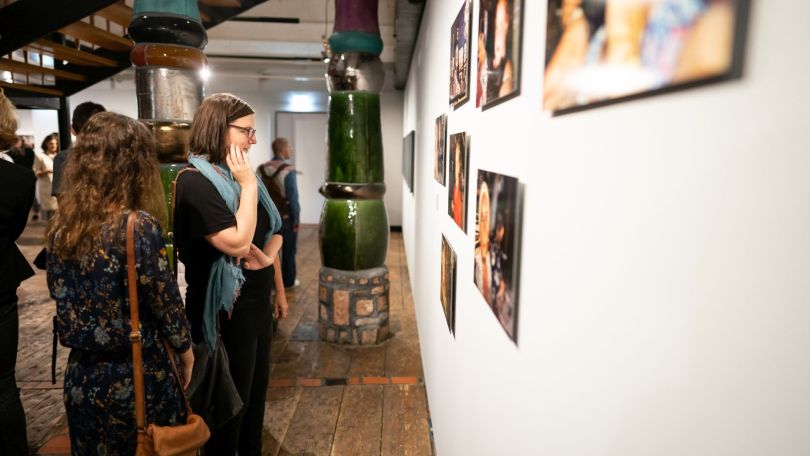 copyright: Wien Holding / David Bohmann Besucherinnen schauen sich Bilder an den Wänden einer Ausstellung an.