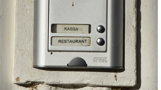 Nahaufnahme der Trklingel des Brigittenauer Bads mit Klingelschild fr "Kassa" und "Restaurant"