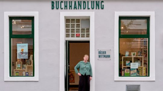 Eine Frau steht vor dem Eingang einer Buchhandlung