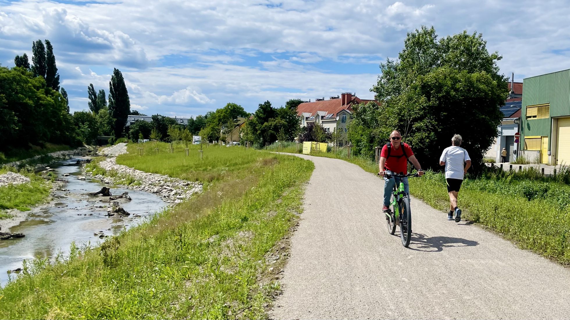 Fahrradfahrer und Jogger unterwegs auf dem Liesingbach-Radweg entlang der Hochwassergasse