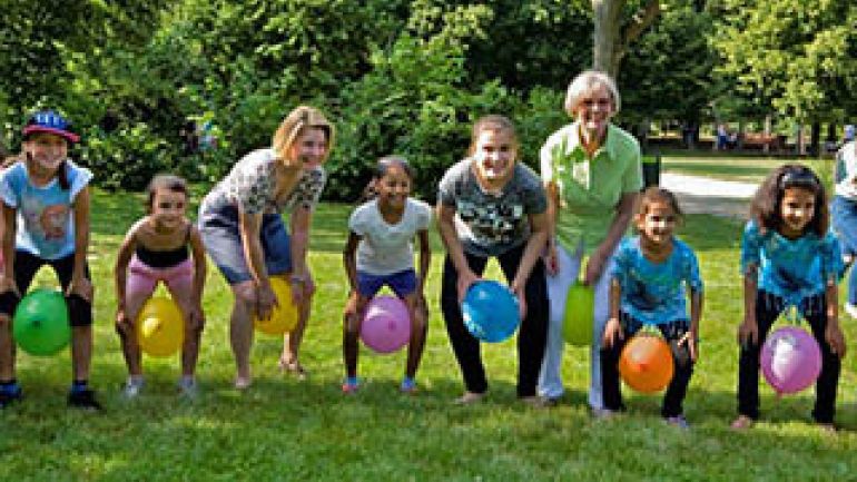copyright: media wien Kinder und Jugendarbeiter sitzen in einer Reihe auf Bällen