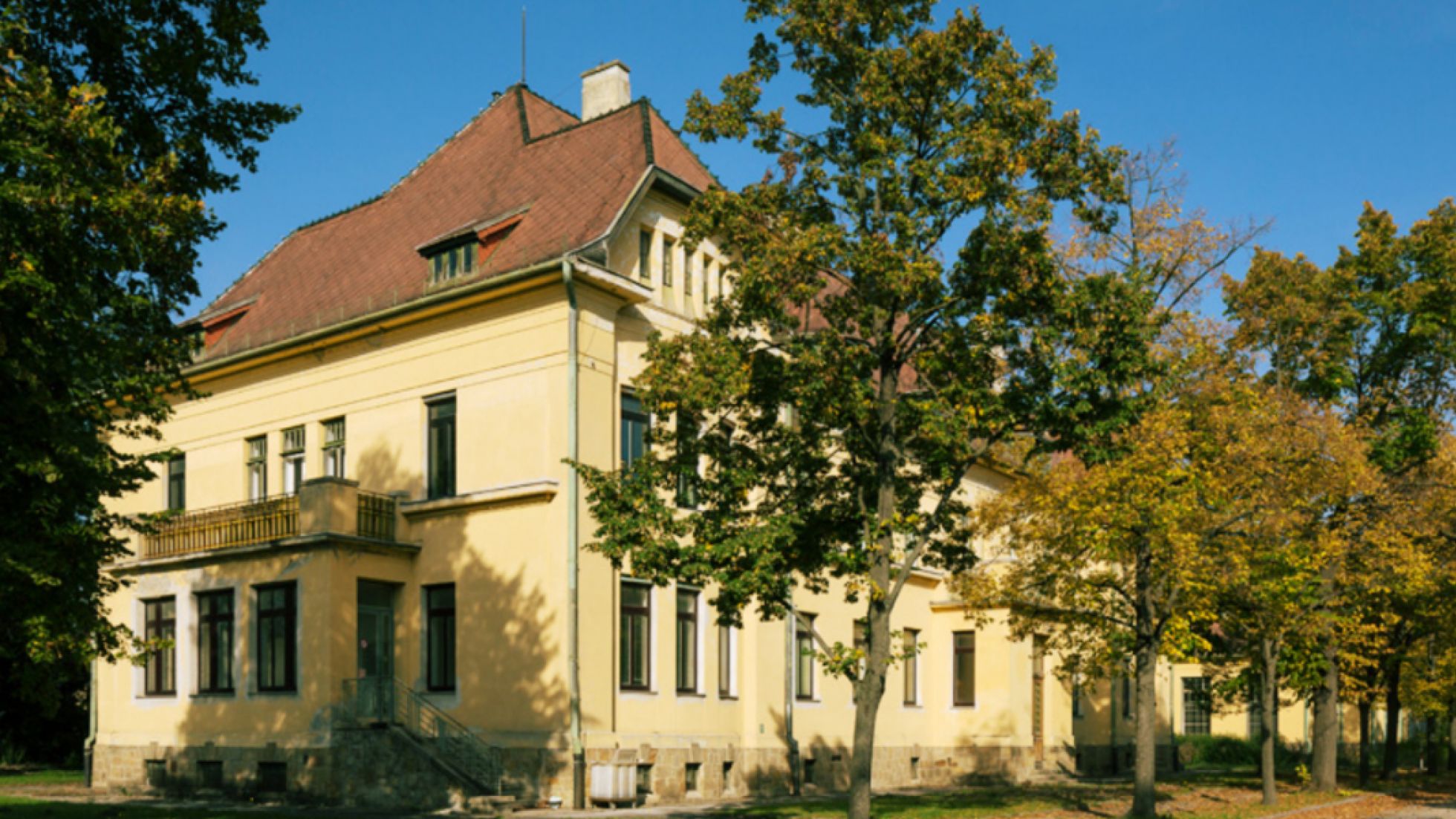 Altes Gebäude, davor Bäume