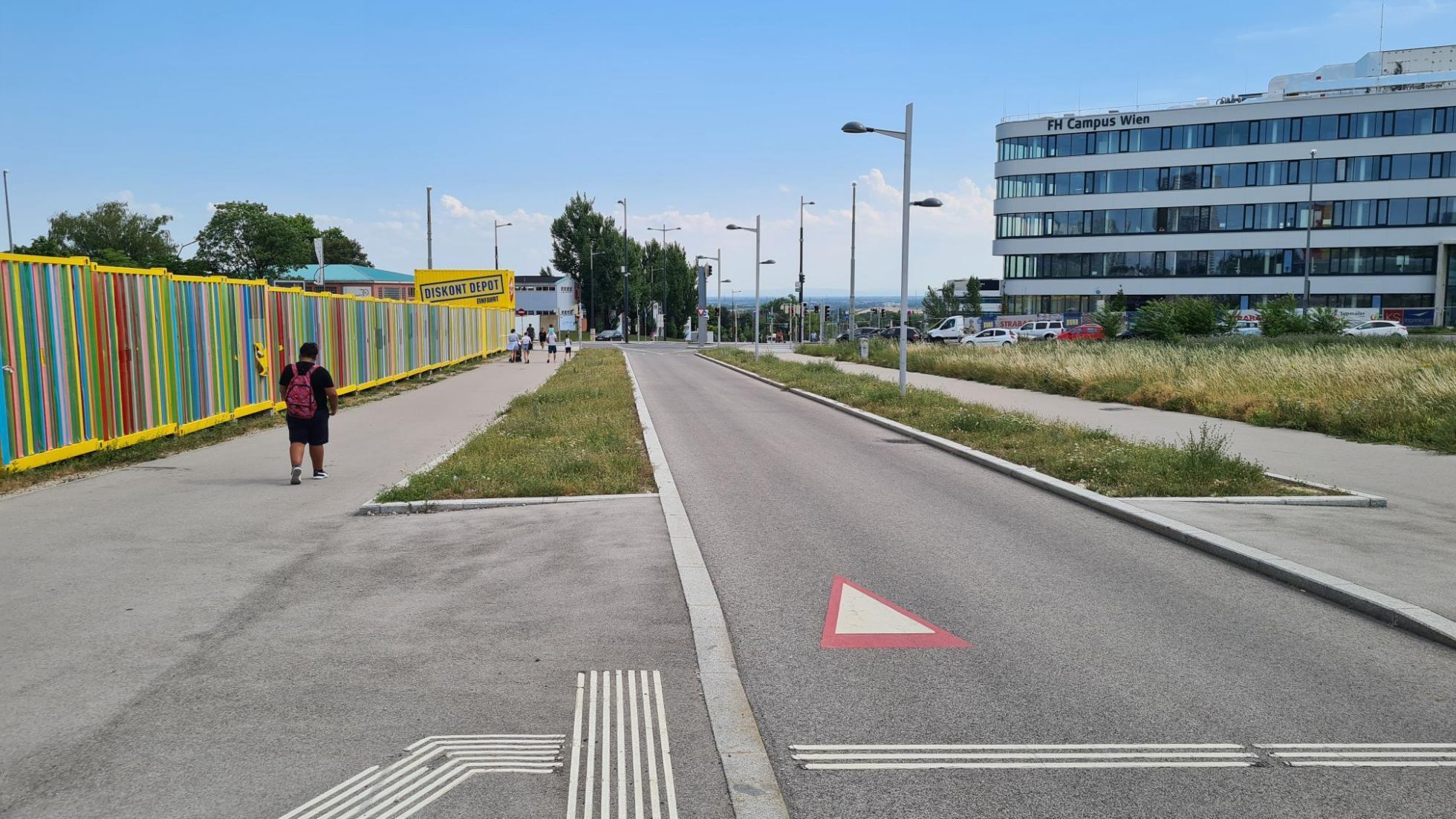 Radweg und Gehweg neben Grasflächen und einem Gebäude