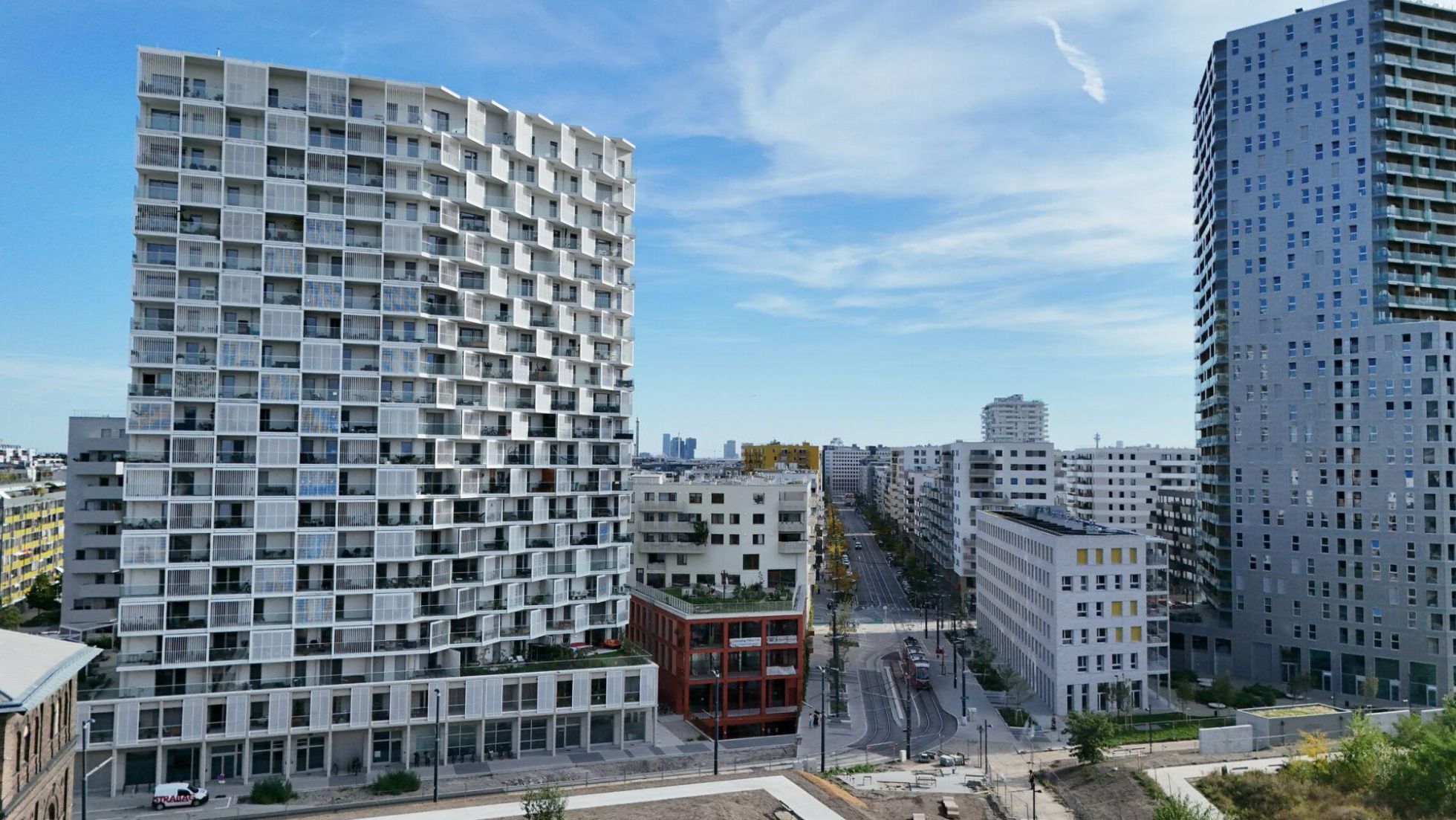 copyright: Stadt Wien/Petra Dworzak 2 höhere Gebäude, dazwischen niedrigere Wohngebäude und eine breite Straße.