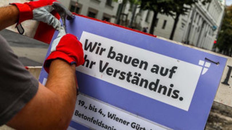 copyright: MA 28/Christian Fürthner Arbeiter bringt eine Baustelleninformation an