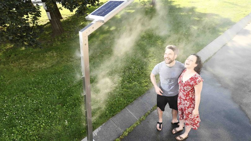 copyright: Wiener Wasser/Zinner 2 Personen stehen in Sommerkleidung unter einer Nebelsteele und kühlen sich ab.