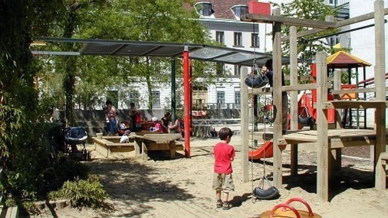 copyright: MA 42 Kinder spielen auf Sandspielplatz mit Federwippe und Kletterturm