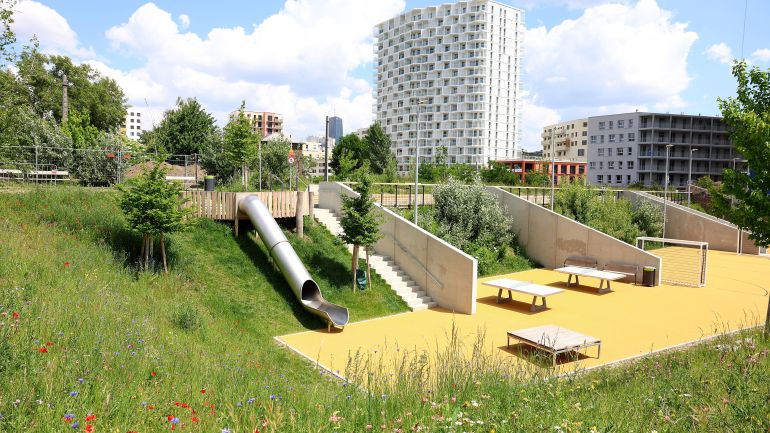 copyright: Wiener Stadtgärten / Votova Spielplatz mit Hangrutsche, dahinter hohe Gebäude