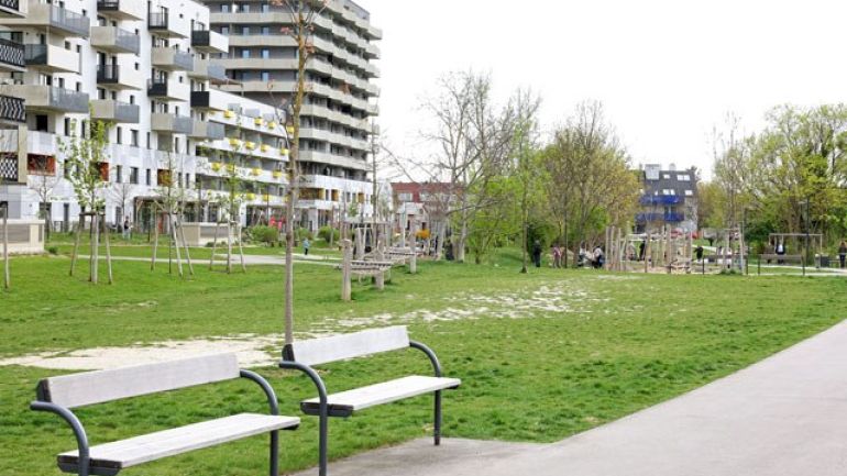 copyright: Stadt Wien/Martin Votava Wiese, Bäume und Sitzgelegenheiten neben Wohnanlage