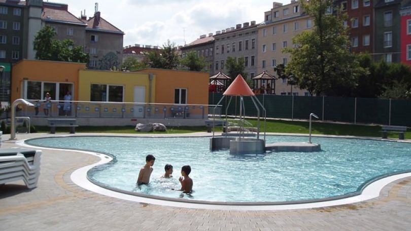 copyright: Wiener Bäder (MA 44) Kinderbecken im Freien mit Rutsche und badenden Menschen