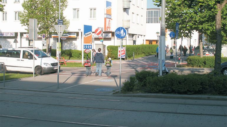 copyright: AUVA Kreuzungsbereich Otto-Probst-Straße - Tesarekplatz: Frau mit Kindern überquert den Zebrastreifen über die Autofahrbahn