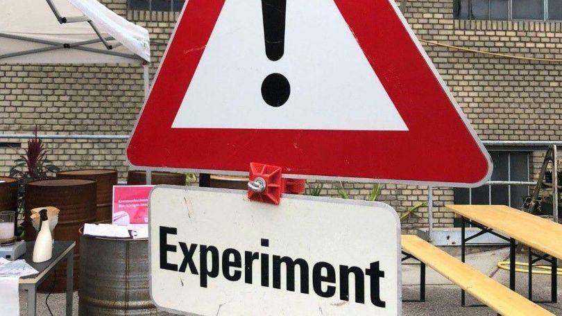 Warnschild mit Hinweis "Experiment"