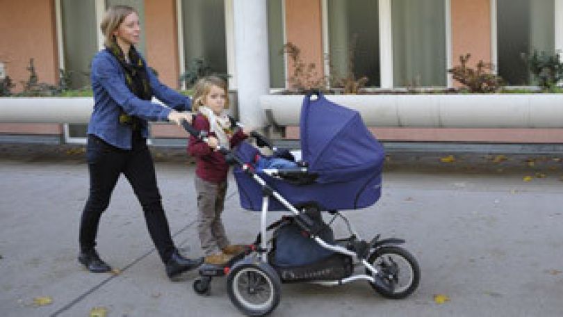 copyright: Frauenservice der Stadt Wien (MA 57) Eine Mutter schiebt mit Kind einen Kinderwagen.