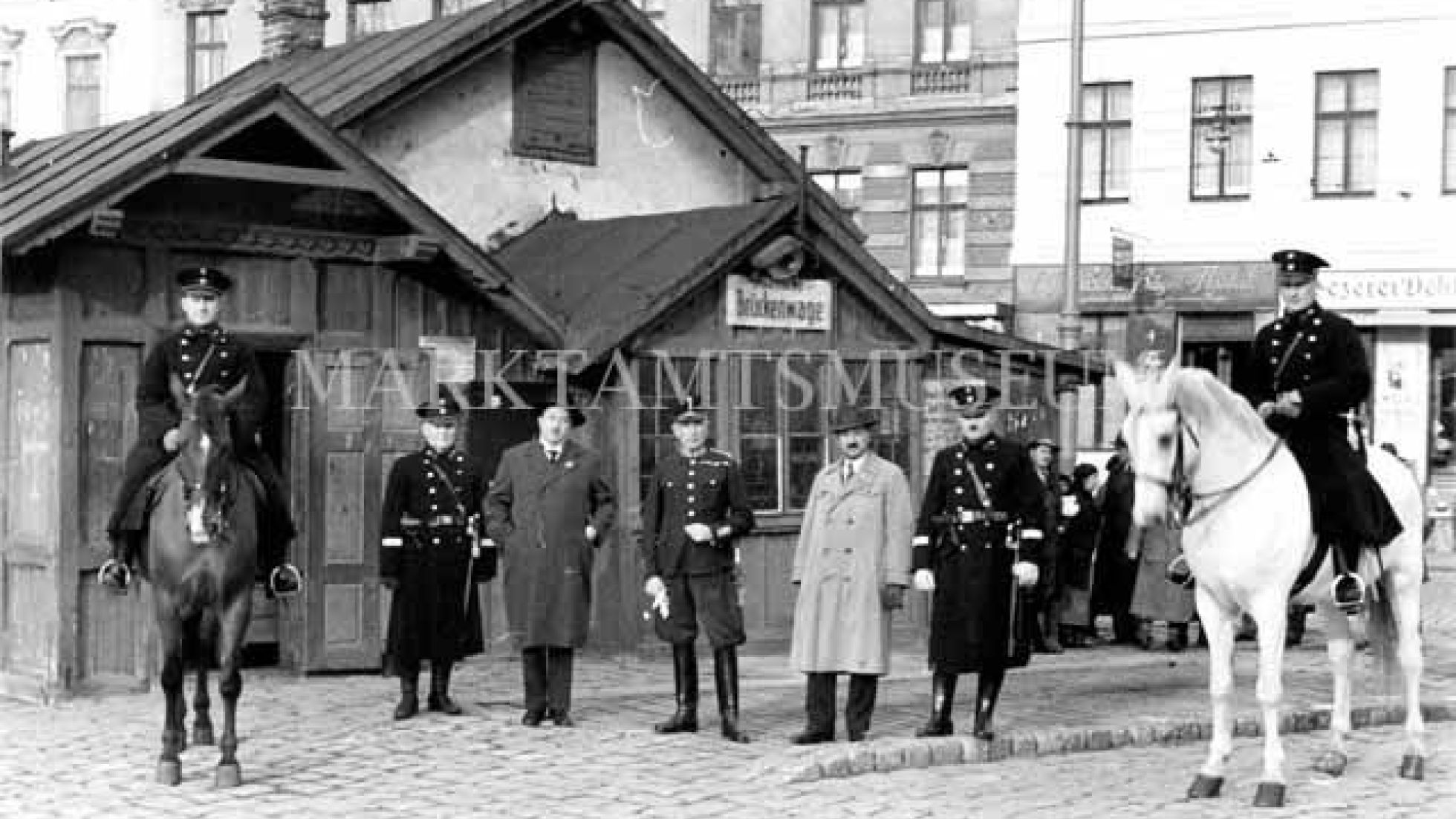 copyright: MA 59 Sieben Männer - fünf davon in Uniform, zwei auf Pferden