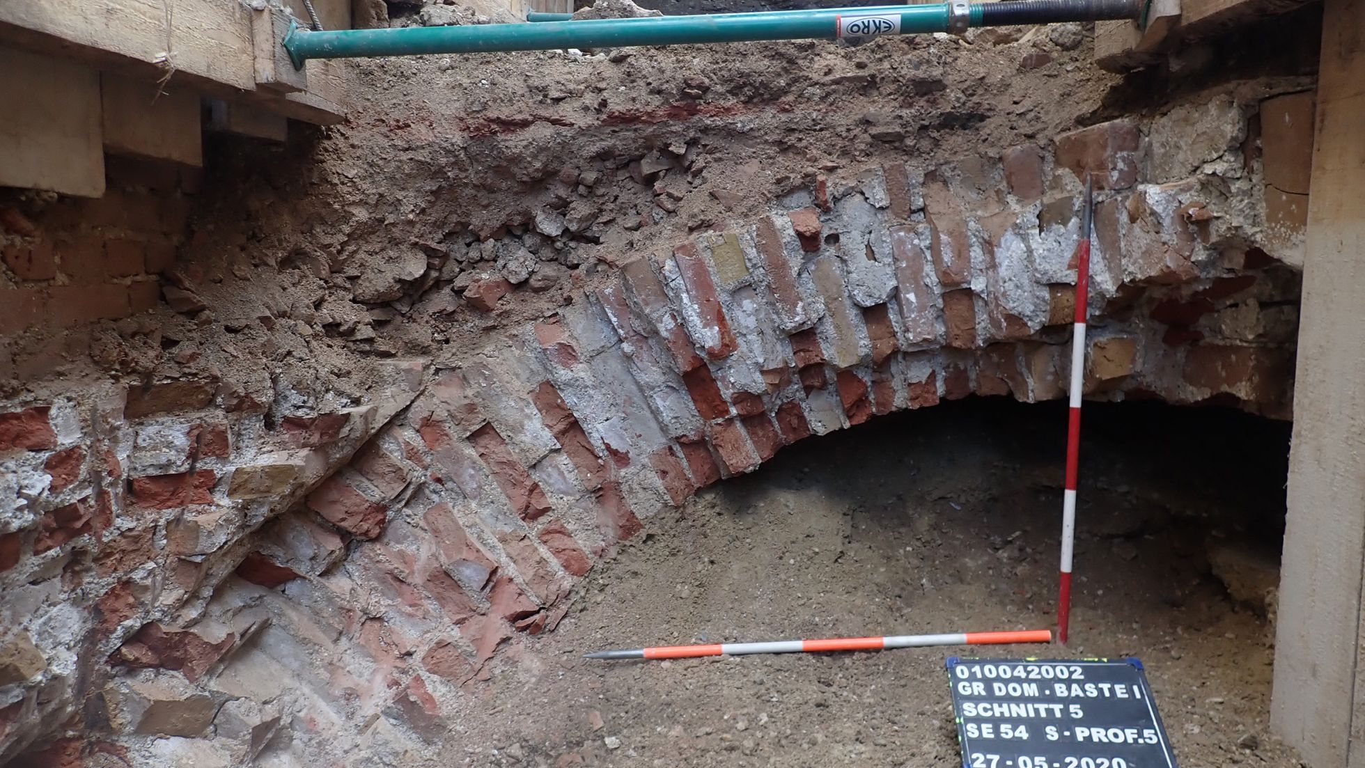 copyright: Stadtarchäologie Wien Aufgegrabene bogenartige Ziegelmauer mit Maßstock