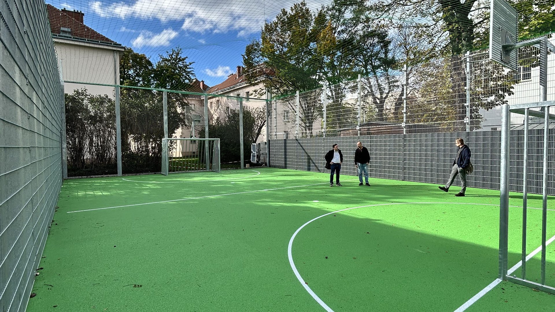 3 Personen auf einem Sportplatz