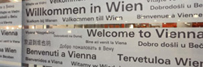 Schild mit Aufschrift "Willkommen in Wien" in mehreren Sprachen