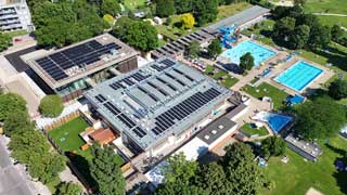 Blick von oben auf das Grofeldsiedlungsbad mit Photovoltaikanlagen am Dach, 3 Auenbecken, Liegewiese, Sportpltze, Wasserrutsche