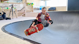 Mann auf Skateboard in der Halfpipe