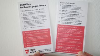 Zwei Hnde halten die "Checkliste bei Gewalt gegen Frauen"