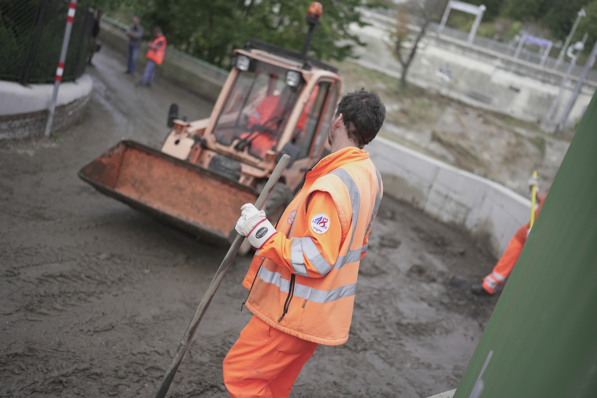 Die MA 48 hat mit den Aufräumarbeiten in den von Überflutungen betroffenen Gebieten begonnen. Im Bild ein Mitarbeiter und Bagger in der Ludwiggasse in Penzing.