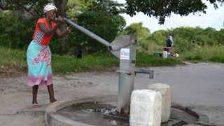 Frau an einer Wasserpumpe in Mosambik