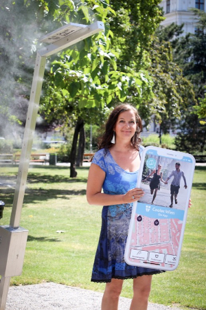 Uli Sima in Park mit Schild mit Lauf-App im Handy-Design