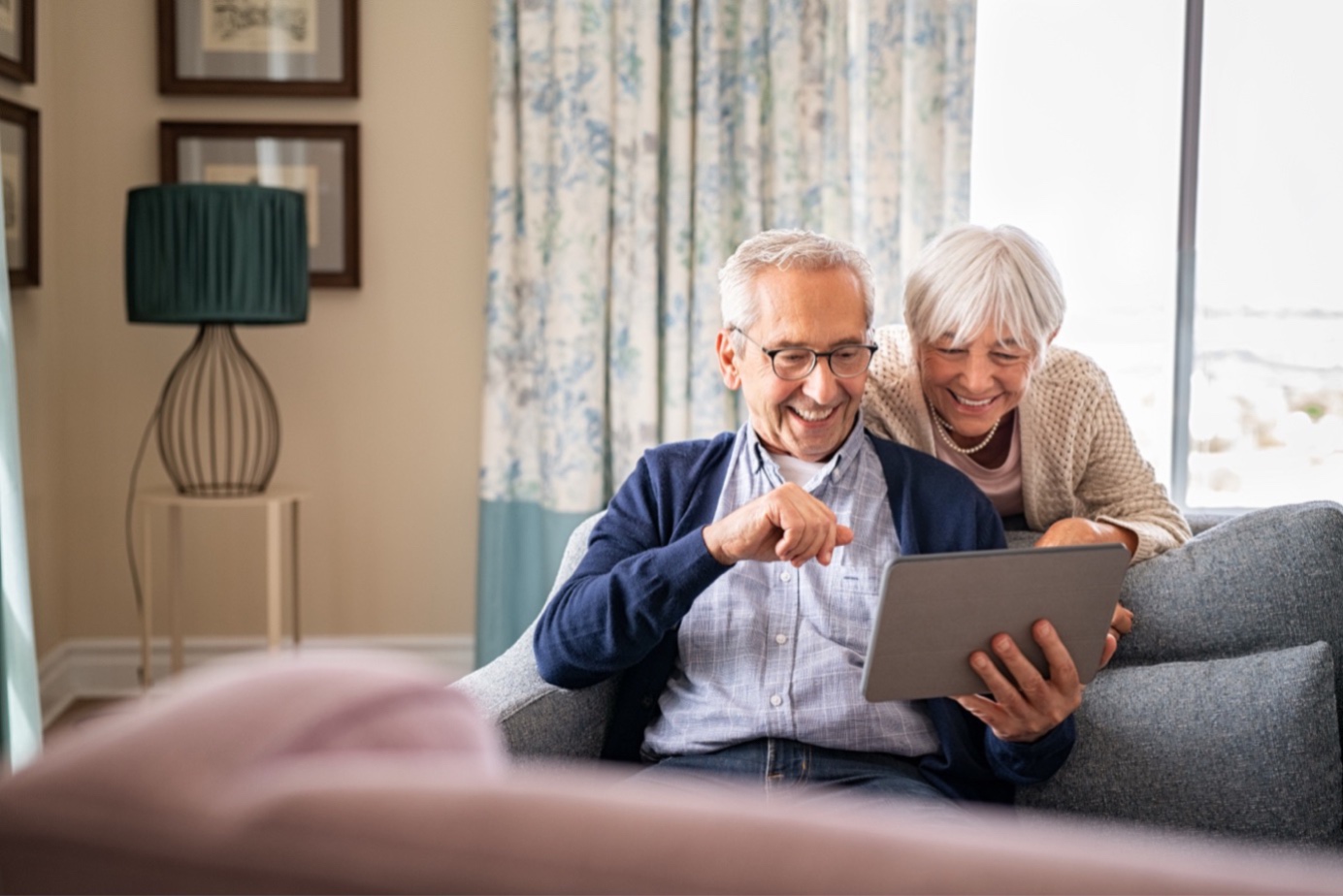 Älteres Paar im Wohnzimmer mit Tablet