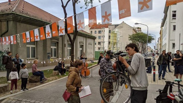 "Wohnstrassenleben" event

Street festival with bike repair point in the foreground and orange-white festoons of the Urban Renewal Office stretching across the street