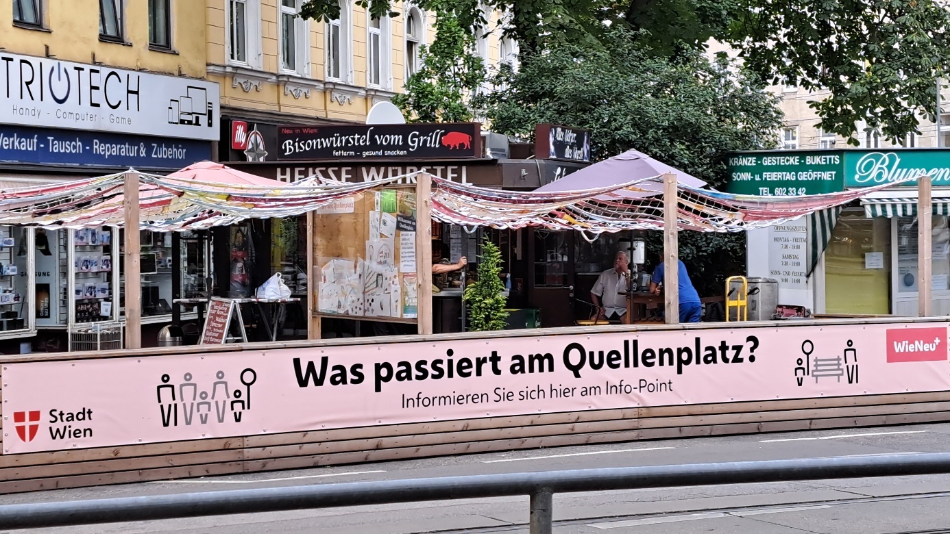 Parklett mit in rosa gehaltenem Schriftzug Was passiert am Quellenpatz? Copyright: Stadt Wien / Bojan Schnabl