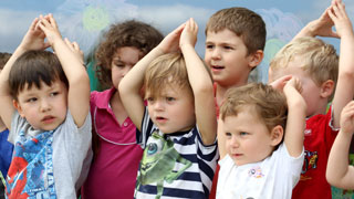 A bunch of children raising their hands